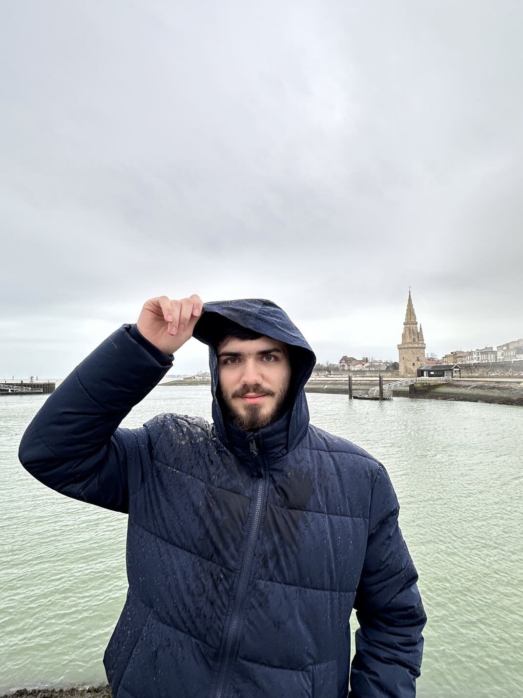 Plan italien noir et blanc sur fond bleu d’Alexian Saby, développeur fullstack de l’agence WebMarmottes, léger sourire, les yeux fermés, la tête dirigée vers le ciel.